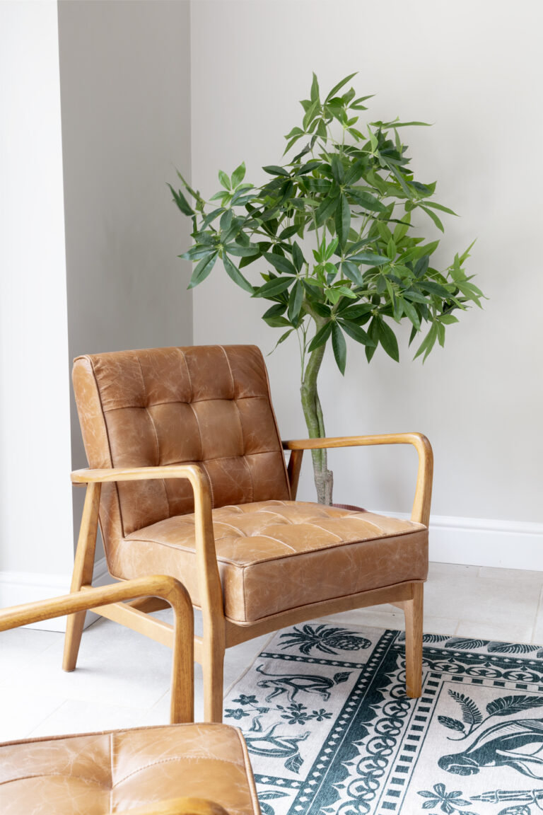 neurodivergent-friendly-office-spaces-dorset. Neurodivergent waiting room in a commercial office. Plant, soft leather chair and calming green rug. Commercial Interior Design Dorset. Hotel Interior Design Dorset.